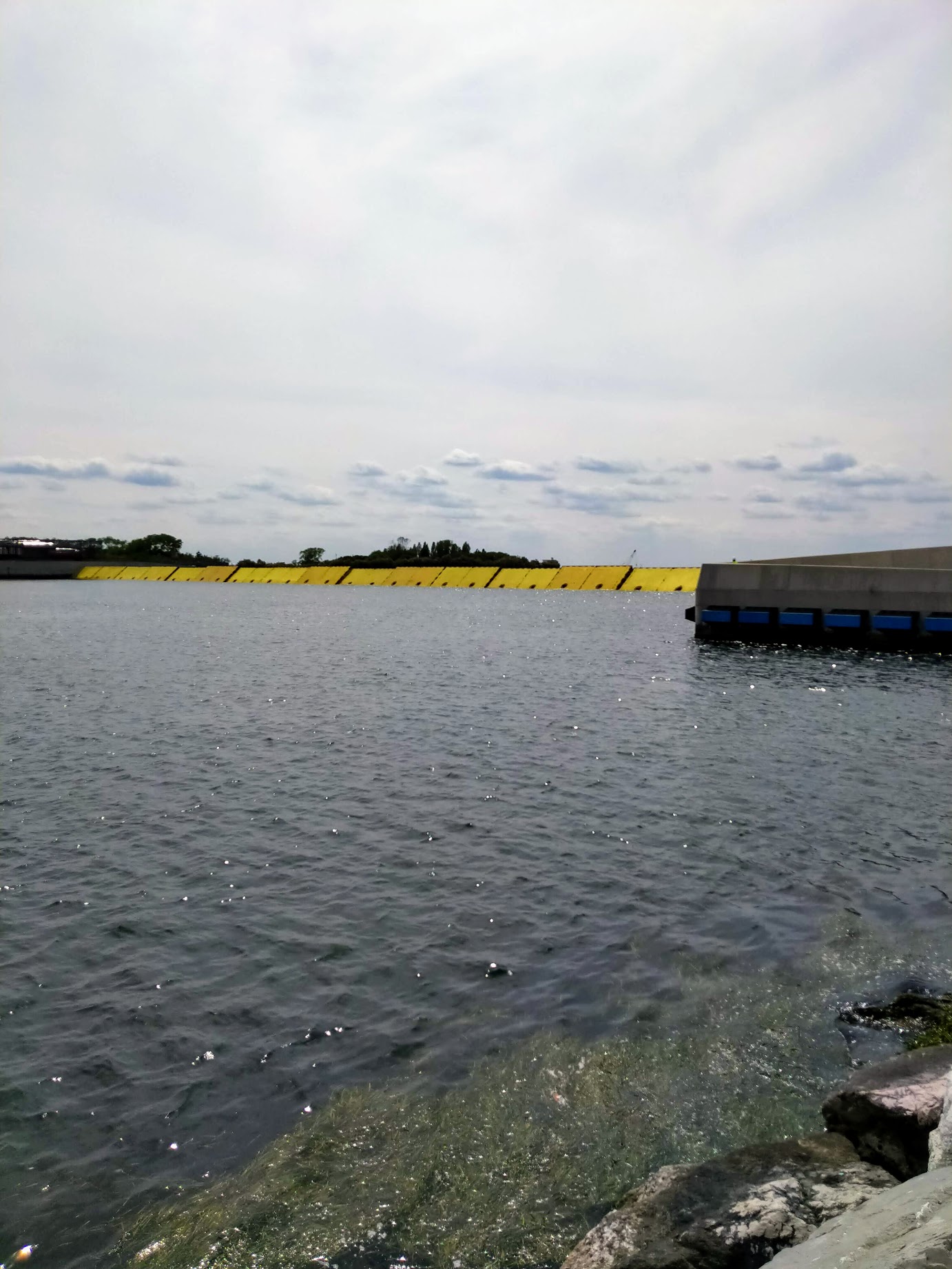 A row of yellow MOSE barriers raised above the water